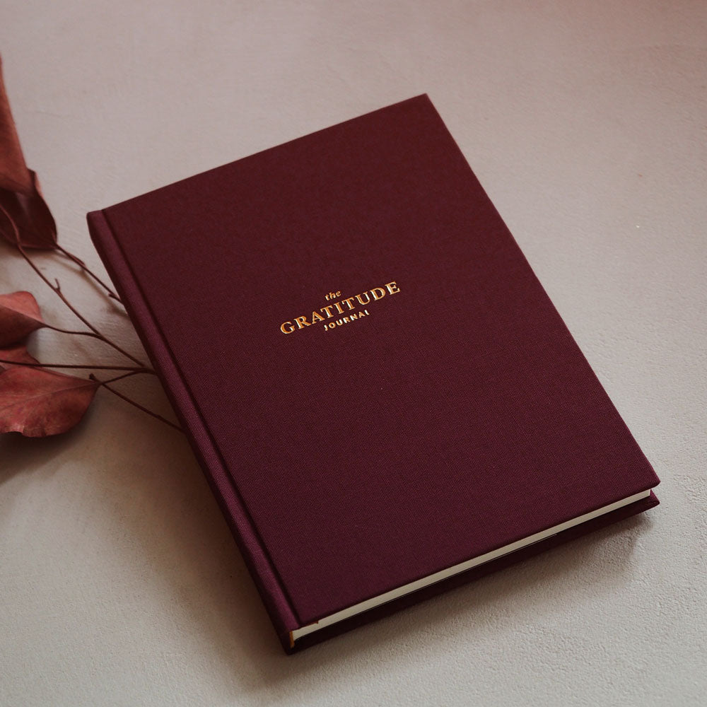 Dziennik wdzięczności Gratitude Journal - purpurowy dziennik gotowy do zapisywania pozytywnych myśli.